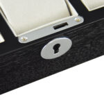 watch case lock detail on black wood veneer surface