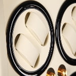Watch winder close-up showing two beige watch cushions in a black circular winding position