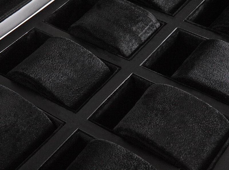 watch case interior with black velvet cushions and compartments