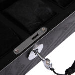 watch case lock detail on black wood veneer surface