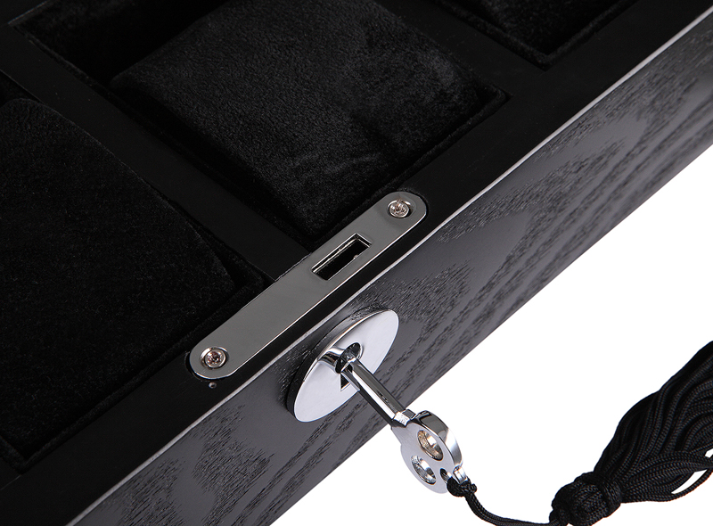 watch case lock detail on black wood veneer surface