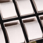 12 watch case interior with beige velvet-wrapped compartments and individual padded holders