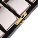Watch case interior with beige padded holders and gold-tone hardware lock detail