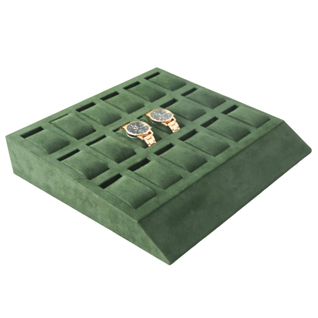 Green velvet watch tray displaying watches in compartments