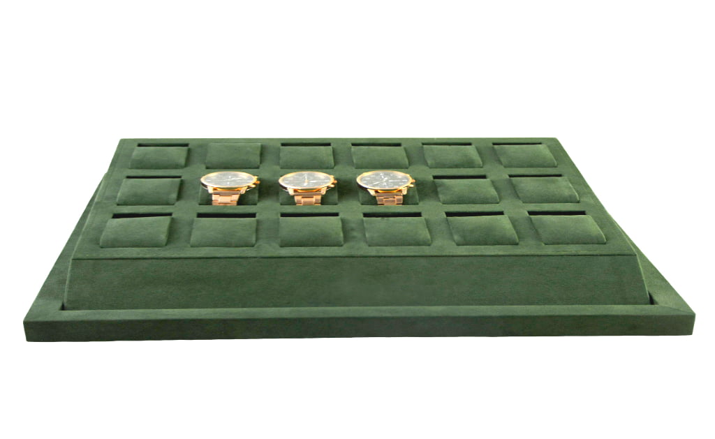 Green velvet watch tray displaying watches in compartments