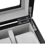 Carbon fiber watch box interior detail showing metal hinge and lid support hardware