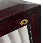 High-gloss ebony watch strap cabinet close-up with gold-tone hardware lock and beige interior