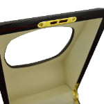 Ebony watch winder close-up showing gold-tone lid hardware and beige interior