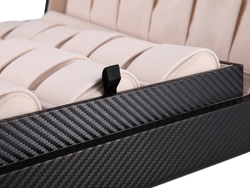 Carbon fiber watch case interior with beige watch cushions and pull tab