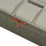 Grey watch box displaying wrist watches with individual cushions
